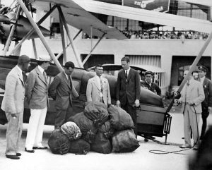 Lindbergh and Merrit next to their plane with mail bags